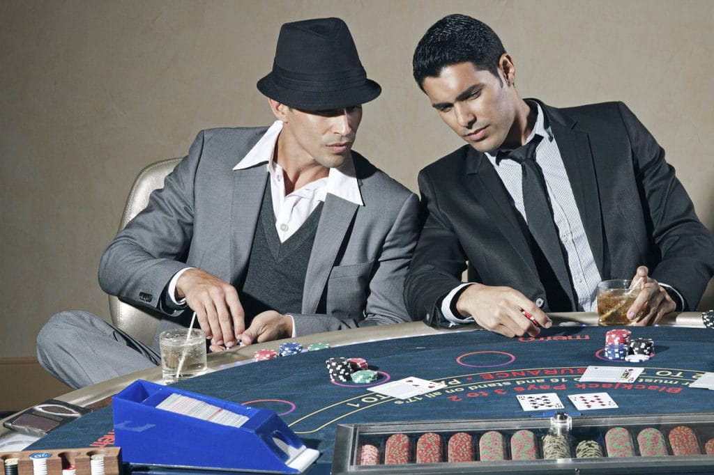 Zwei Gentlemen sitzen an einem Pokertisch